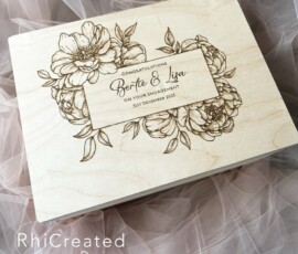 Top view of a wooden box with a floral design and test wood burned into the top for a wedding